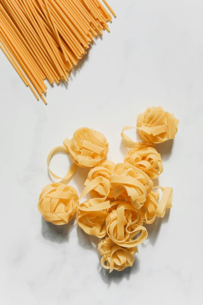 Pâtes sur un fond blanc, non cuite, spaghetti et linguine.