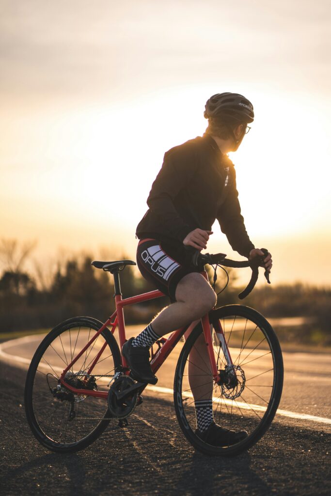 Personne qui est sur son vélo et qui regarde le couché du soleil.